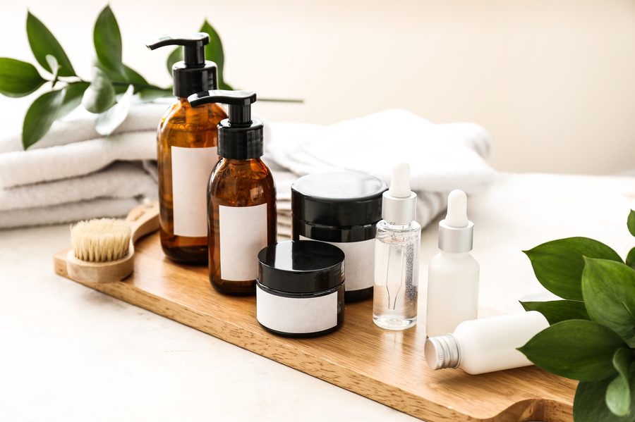 Bodegón de cosmética con frascos ámbar y toallas