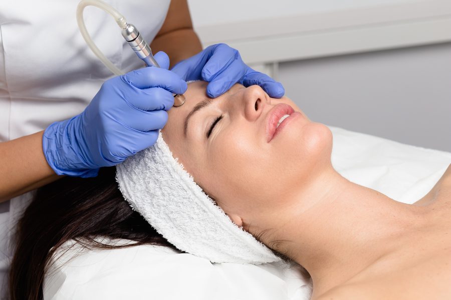 Esteticista aplicando aparatología facial a una clienta